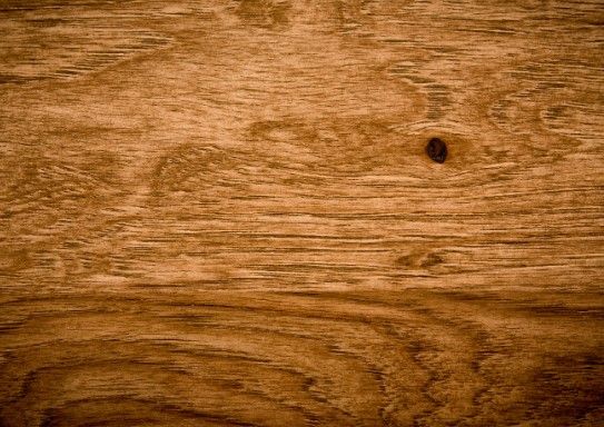 Tablero de madera en tono miel con veta marcada y un nudo