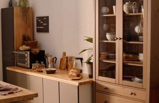 Vitrina de madera con puertas de cristal junto a una encimera de madera